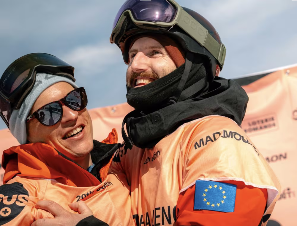 Two athletes celebrating, one wearing an EU flag patch on his sleeve